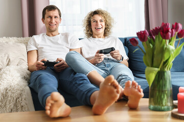 Couple with a gamepads are playing video game console