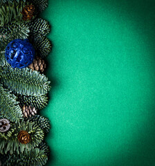 Green Christmas background. Background with fir branches, cones and toys.