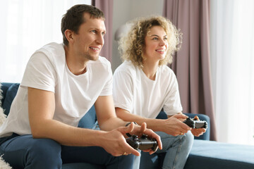 Couple with a gamepads are playing video game console