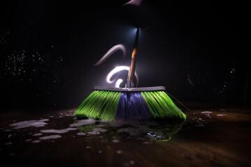 close-up brush the floor on a dark background with light and fog. Broom in dark. Cleaning concept.