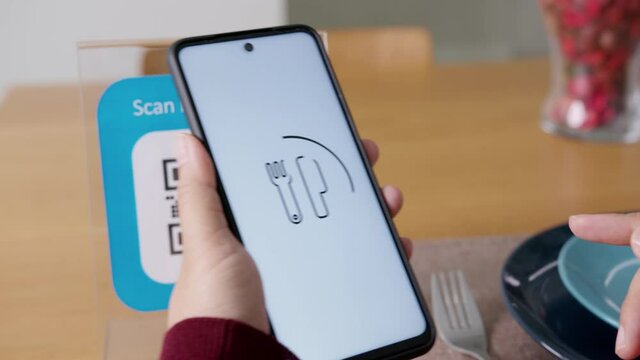 Hand's customer scan QR code for online menu service at table in restaurant during pandemic coronavirus. New normal contactless technology lifestyle protection coronavirus pandemic in restaurant
