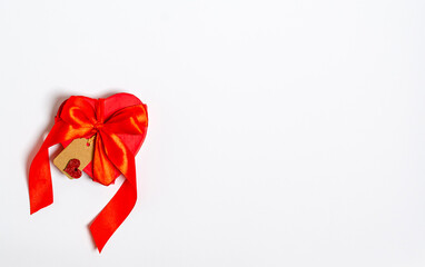 Red gift box in the form of a heart with a ribbon and a tag for congratulations on a white background