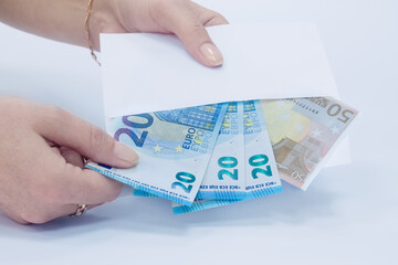 white envelope with 20 and 50 Euro banknotes in a woman's hand