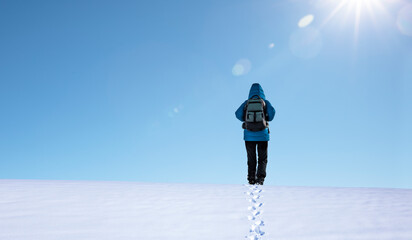 Person mit Blaue Jacke wandert im Schnee
