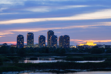 Vacaresti Park Nature Reserve in Bucharest, Romania, after sunset, with skyscrapers and Palace of Parliament, part of the city skyline. Nature, landmark, tourism, sightseeing