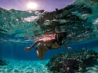 Young woman snorkeling at coral reef of Red Sea