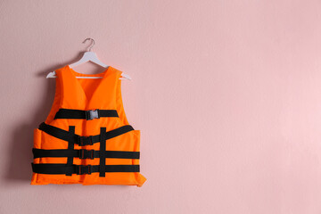 Orange life jacket on pink background. Space for text