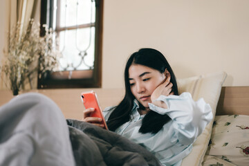 Young adult single woman using smartphone in the moring for social message app chat with friend