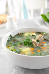 Delicious sorrel soup with meat served on marble table, closeup