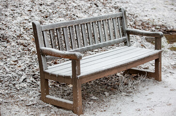 Close up of a frozen wooden bench during lovely winter time