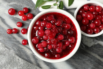 Flat lay composition with cranberry sauce and fresh berries on marble board