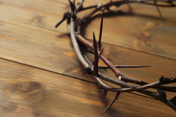 Crown of thorns on wooden table, closeup with space for text. Easter attribute