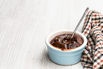 Hot chocolate lava cake in clay pot on white wooden table