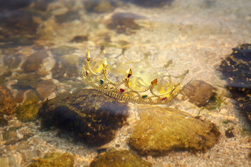 Beautiful golden crown under water in river. Fantasy item