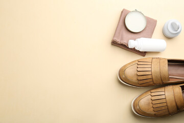 Flat lay composition with shoe care accessories and footwear on beige background. Space for text