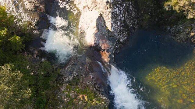 Aerial view of a mountain stream cascading into a clear pool at Pirio in Corsica