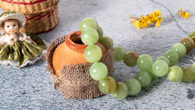 Amazing glittering necklace made of large beads of natural stone onyx on an old  clay pot. Retro composition of jewelry and vintage decor. 