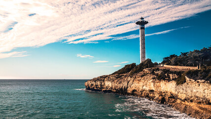 Rocky coast with a lighthouse, Mediterranean sea, Torredembarra, Tarragona, Spain.