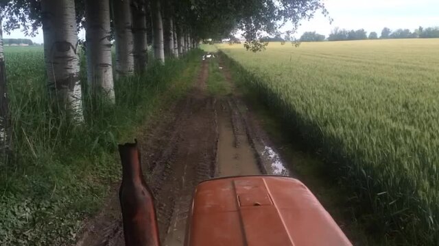 The tractor rides on the field view from the cabin, time lapse