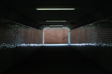 The exit of a pedestriantunnel leads to a brick wall.