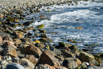 View of a rocky beach on which the waves of the sea break