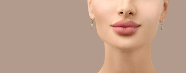 Beautiful young model face closeup. Lip filler injections. Fillers. Lip augmentation. Perfect Lips with hyaluronic acid. Sexy Mouth close-up. Beauty young woman Lips. Close up over grey background 