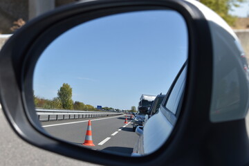 View of traffic jam on the side mirror at highway due to road works