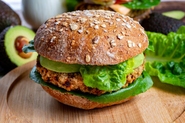 Tasty vegetarian healthy food, homemade burgers made from orange lentils legumes with green lettuce and fresh ripe avocado