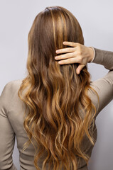 Young woman showing her beautiful hair after dyeing and styling