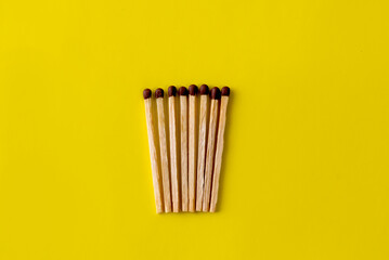 wooden matches on a yellow background. lots of matches for the fire