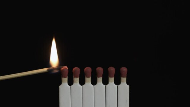 Slow motion. Igniting and burning a line of matches. The matches ignite from each other.
