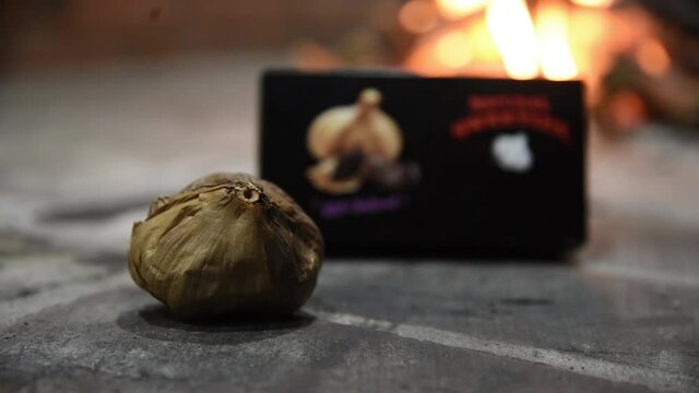 Whole black garlic bulb and peeled organic cloves on a dark background premium ingredient
