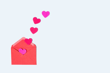 Red and purple hearts emerging from a red envelope on a light blue background