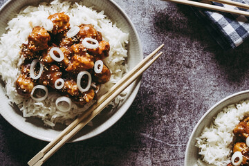 Choux-fleur caramélisé aux graines de sésame et petits oignons accompagné de riz blanc dans une assiette - Plat gourmand asiatique