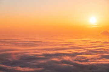 Beautiful sunset sky above clouds, dramatic sunset sky. Nature background, aerial view.