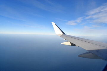 Fototapeta na wymiar Beautiful horizon blue sky with white wing of airplane fiying on the air.