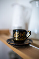black mug with patterns and print of ancient Greek mythology