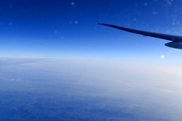 Beautiful horizon blue sky with  airplane wing fiying on the air.  Viewed from airplane window.