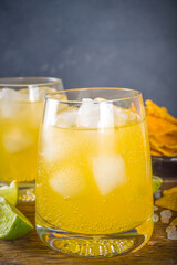 Summer boozy citrus cocktail, citrus margarita, tequila drink with salt and Mexican chips, Summer cold cocktail concept, copy space