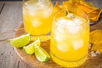 Summer boozy citrus cocktail, citrus margarita, tequila drink with salt and Mexican chips, Summer...