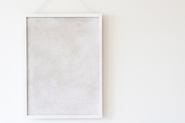empty white cork board hanging on the wall. horizontal copy space