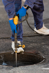 The plumber prepares to fix the problem in the sewer. Repair work on troubleshooting. Close up.