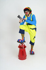 The clown firefighter holds a fire barrel in his hands, extinguishes the fire.