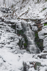 Fototapeta na wymiar Waterfall on Bucaci creek in Moravskoslezske Beskydy mountains in cold snowy day