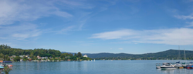 Boating and sailing on the clear waters of alpine Lake Worthersee, famous tourist attraction for many water activity in Klagenfurt, Carinthia, Austria