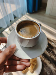 Mobile point of view image of woman holding modern smartphone and taking pictures of her morning breakfast coffee and tasty croissants buns to share photos on social media resources