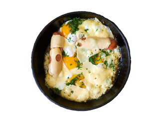 Fried eggs with sausages, herbs and cheese in a pan. Isolated on white.