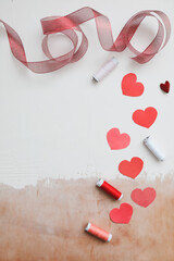 Love Background with paper hearts and red ribbon. Space for text on white background. Valentines day concept. Greetings. Copy space. Flat lay, top view