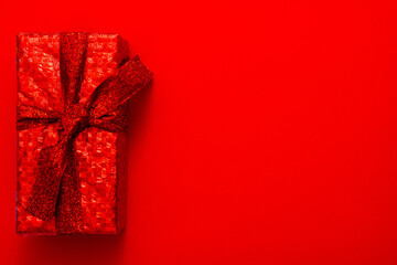 Gift in a red package on a red background. Christmas, Valentine's Day gift.
