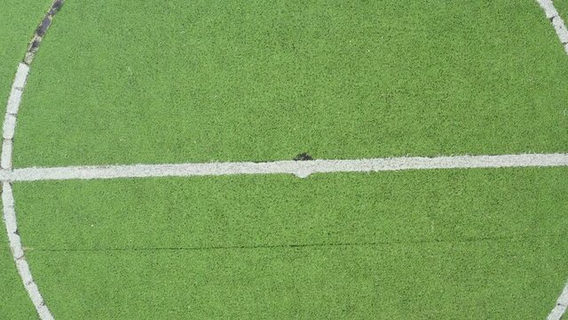 Midpoint of an artificial grass football field zooming out to reveal the whole field